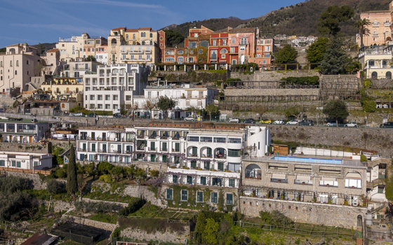 Aerial view of sun kissed buildings cascade down the hillside with vibrant colors contrasting against the lush greenery Ravello Salerno Italy Aerial view of sun kissed buildings cascade down the hillside with vibrant colors contrasting against the lush greenery Ravello Salerno Italy