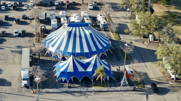 Aerial view of a blue and white striped circus tent rises from a parking lot filled with cars and RVs creating a vibrant scene St. Augustine Florida United States. Aerial view of a blue and white striped circus tent rises from a parking lot filled with cars and RVs creating a vibrant scene St. Augustine Florida United States.