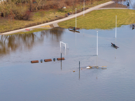 Aerial view of a flooded park with a soccer goal benches and lamp posts partially submerged in water during a spring flood in Kedainiai Kaunas County Lithuania. Aerial view of a flooded park with a soccer goal benches and lamp posts partially submerged in water during a spring flood in Kedainiai Kaunas County Lithuania.