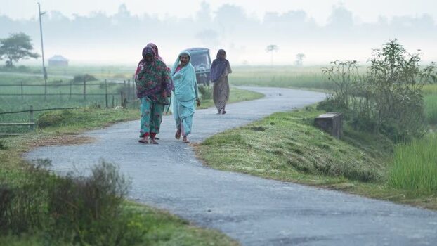 View of women walking on a rural road in Bogura Bangladesh.