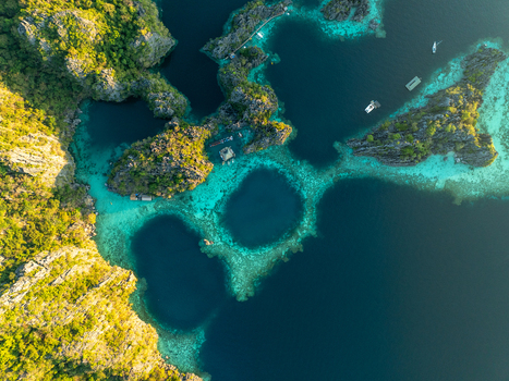 Aerial view of Twin Lagoon with turquoise waters limestone cliffs and small boats in Coron Mimaropa Philippines. Aerial view of Twin Lagoon with turquoise waters limestone cliffs and small boats in Coron Mimaropa Philippines.