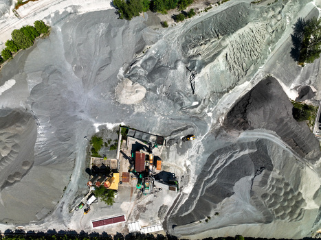 Aerial view of an industrial quarry with large piles of grey gravel and processing machinery in Caprie Piedmont Italy. Aerial view of an industrial quarry with large piles of grey gravel and processing machinery in Caprie Piedmont Italy.