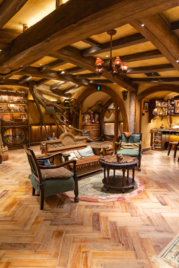View of a cozy interior with wooden beams and furniture soft lighting enhancing the warm color palette creating an inviting atmosphere Hobbiton New Zealand. View of a cozy interior with wooden beams and furniture soft lighting enhancing the warm color palette creating an inviting atmosphere Hobbiton New Zealand.