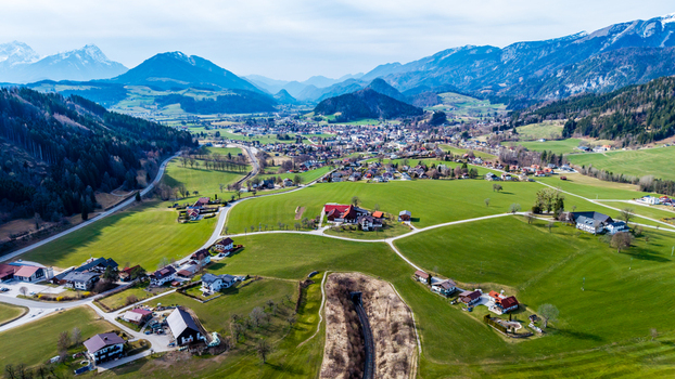 Aerial view of lush green fields meeting quaint villages nestled in the Windischgarsten valley framed by snow capped mountains under a pastel sky Windischgarsten Upper Austria Austria. Aerial view of lush green fields meeting quaint villages nestled in the Windischgarsten valley framed by snow capped mountains under a pastel sky Windischgarsten Upper Austria Austria.