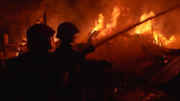 View of firefighters battling a large fire at night Bangladesh. View of firefighters battling a large fire at night Bangladesh.