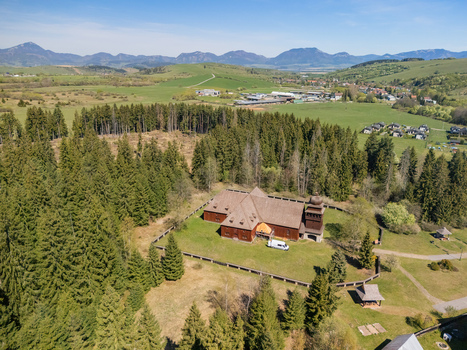Aerial view of the Wooden Articular Church of Svaty Kriz surrounded by lush forests and rolling hills Svaty Kriz Zilinsky kraj Slovakia.