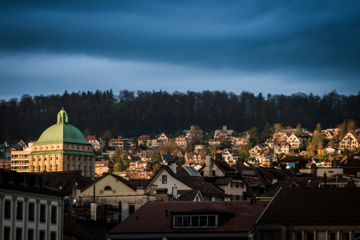Zurich Switzerland 02 April 2023 View of the Urania Sternwarte s green dome contrasting against the rooftops and dark forest bathed in the warm glow of the setting sun. Zurich Switzerland 02 April 2023 View of the Urania Sternwarte s green dome contrasting against the rooftops and dark forest bathed in the warm glow of the setting sun.