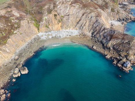 Aerial view of Nez de Jobourg featuring rugged cliffs and a secluded turquoise cove along the coastline in La Hague Normandie France. Aerial view of Nez de Jobourg featuring rugged cliffs and a secluded turquoise cove along the coastline in La Hague Normandie France.