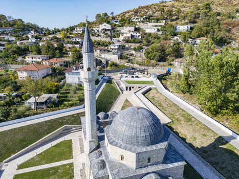 Aerial view of the Lead Mosque with its distinctive dome and minaret surrounded by landscaped grounds and residential buildings in Shkoder Shkoder County Albania. Aerial view of the Lead Mosque with its distinctive dome and minaret surrounded by landscaped grounds and residential buildings in Shkoder Shkoder County Albania.