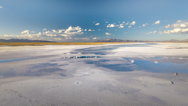 Aerial view of Salinas Grandes salt flat with shallow water pools reflecting the blue sky and distant mountains in La Poma Department Salta Province Argentina. Aerial view of Salinas Grandes salt flat with shallow water pools reflecting the blue sky and distant mountains in La Poma Department Salta Province Argentina.