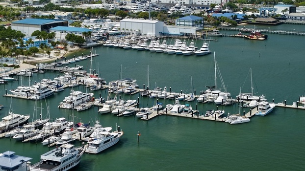 Aerial view of Peanut Island marina with numerous luxury yachts and boats docked at white piers along the turquoise coastline Palm Beach County Florida United States.