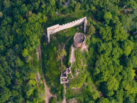 Aerial view of the historic Saint Ulrich castle ruins with a round tower and stone walls surrounded by a dense green forest in Ribeauville Grand Est France. Aerial view of the historic Saint Ulrich castle ruins with a round tower and stone walls surrounded by a dense green forest in Ribeauville Grand Est France.