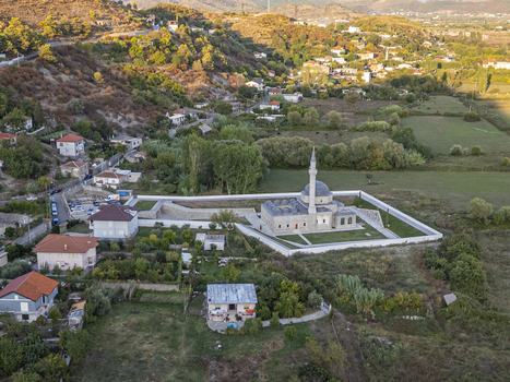 Aerial view of Lead Mosque surrounded by green fields stone walls and residential houses in the rural landscape of Shkoder Shkoder County Albania. Aerial view of Lead Mosque surrounded by green fields stone walls and residential houses in the rural landscape of Shkoder Shkoder County Albania.