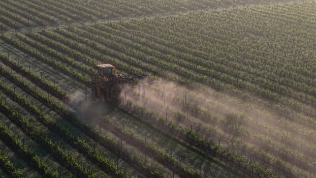 Aerial view of a tractor in a vineyard in Targon France.