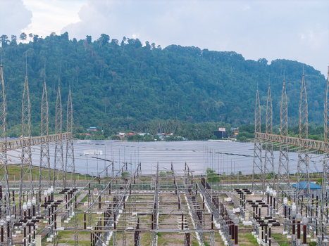 Aerial view of a high voltage transmission substation with metal towers and electrical equipment featuring a solar panel farm in the background Central Seberang Perai Penang Malaysia. Aerial view of a high voltage transmission substation with metal towers and electrical equipment featuring a solar panel farm in the background Central Seberang Perai Penang Malaysia.