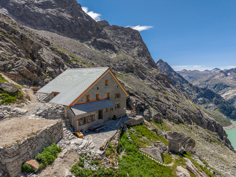 Aerial view of the Gelmerseehutte alpine refuge nestled in the rugged high alpine landscape with stone walls and rocky terrain in Guttannen Canton of Bern Switzerland.
