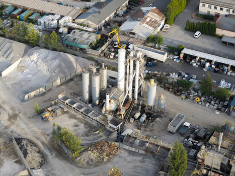 Aerial view of an industrial concrete production facility with tall storage silos heavy machinery and piles of raw materials in Krakow Lesser Poland Voivode Poland. Aerial view of an industrial concrete production facility with tall storage silos heavy machinery and piles of raw materials in Krakow Lesser Poland Voivode Poland.