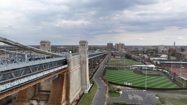 Aerial view of the majestic Ben Franklin Bridge stretching across the frame juxtaposed against the cityscape and baseball field Philadelphia Pennsylvania United States.