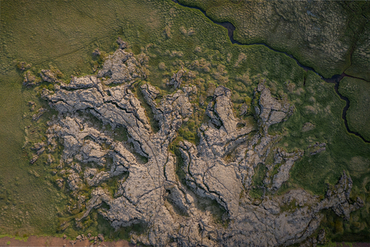 Aerial view of Ytri Raudarmelskula a volcanic crater surrounded by mossy lava fields and green vegetation in Raudhamelur Eyja og Miklaholtshr Iceland. Aerial view of Ytri Raudarmelskula a volcanic crater surrounded by mossy lava fields and green vegetation in Raudhamelur Eyja og Miklaholtshr Iceland.