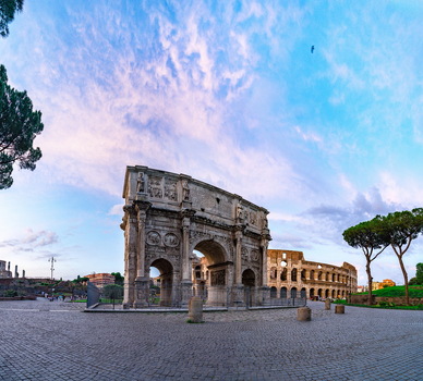 View of the Arch of Constantine and the Colosseum under a blue sky with soft clouds in Rome Lazio Italy. View of the Arch of Constantine and the Colosseum under a blue sky with soft clouds in Rome Lazio Italy.