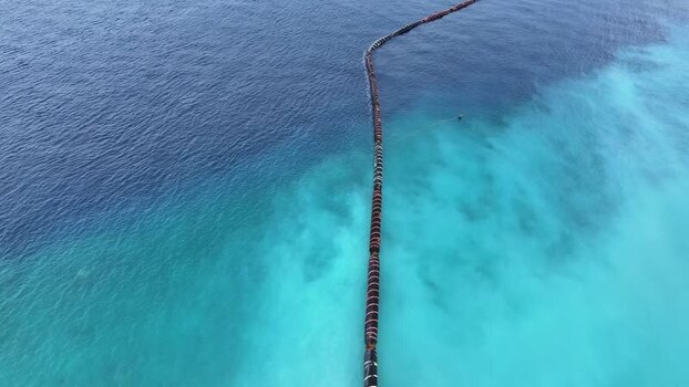 Aerial view of a floating pipeline in the turquoise sea Maldives. Aerial view of a floating pipeline in the turquoise sea Maldives.