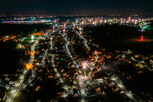 Aerial view of fireworks exploding over the illuminated residential streets and houses at night in Forchheim Bavaria Germany. Aerial view of fireworks exploding over the illuminated residential streets and houses at night in Forchheim Bavaria Germany.