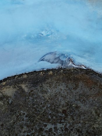 Aerial view of the milky blue geothermal waters of the Reykjanes peninsula contrasting with the dark volcanic rock of Grindavikurbaer Iceland. Aerial view of the milky blue geothermal waters of the Reykjanes peninsula contrasting with the dark volcanic rock of Grindavikurbaer Iceland.