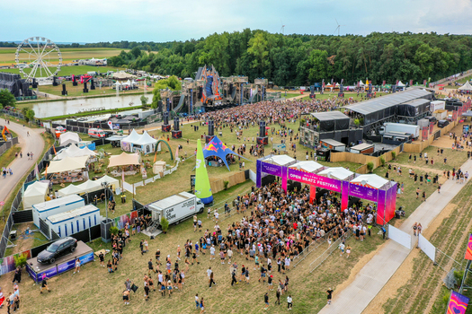 Herzogenaurach Germany 24 July 2025 Aerial view of the Open Beatz Festival featuring a large main stage a Ferris wheel and crowds of people gathered in an open field surrounded by trees.