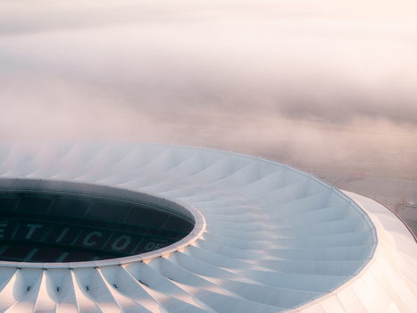 Aerial view of the Riyadh Air Metropolitano Stadium with its distinctive white roof partially shrouded in morning mist in Madrid Comunidad de Madrid Spain.