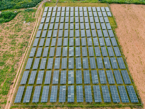 Aerial view of a large solar farm with rows of photovoltaic panels installed in a rural landscape in Ogun State Nigeria.