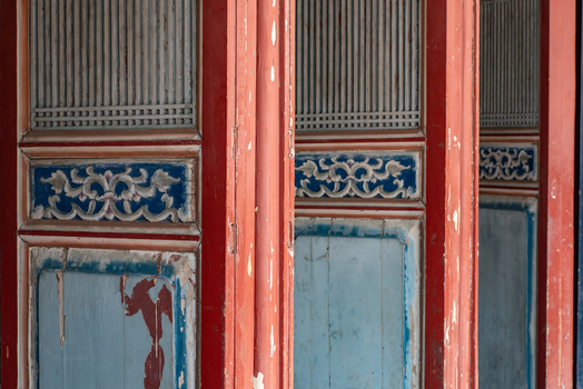 View of weathered traditional wooden doors with intricate carvings and peeling paint at Chihkan Tower in Chihkan Village Tainan City Taiwan. View of weathered traditional wooden doors with intricate carvings and peeling paint at Chihkan Tower in Chihkan Village Tainan City Taiwan.