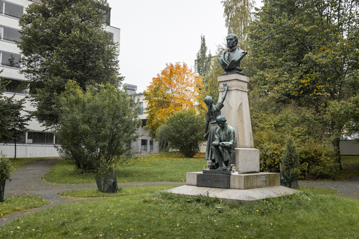 View of the Minna Canth statue in a park with autumn foliage and a building in the background in Jyvaskyla Central Finland Finland.