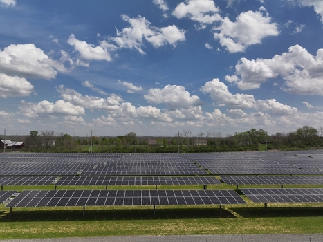 Lebanon United States 12 April 2026 Aerial view of a large solar farm with rows of photovoltaic panels installed on a green field under a blue sky with white clouds.