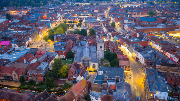 Aerial view of St Thomas s Church surrounded by historic red tiled rooftops and illuminated streets in the city center of Salisbury England United Kingdom. Aerial view of St Thomas s Church surrounded by historic red tiled rooftops and illuminated streets in the city center of Salisbury England United Kingdom.