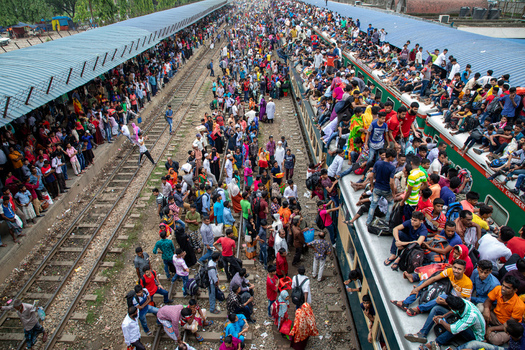 Dhaka Bangladesh 15 June 2018 View of Airport Railway Station crowded with people sitting on train roofs and platforms during the Eid al Fitr holiday rush. Dhaka Bangladesh 15 June 2018 View of Airport Railway Station crowded with people sitting on train roofs and platforms during the Eid al Fitr holiday rush.