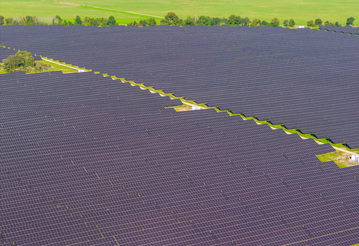 Aerial view of a large solar farm with rows of photovoltaic panels installed in a rural landscape in Pomeranian Voivodeship Poland. Aerial view of a large solar farm with rows of photovoltaic panels installed in a rural landscape in Pomeranian Voivodeship Poland.