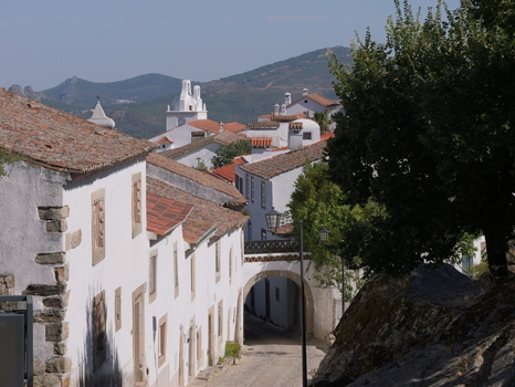 View of the historic white walled houses with terracotta roofs and a stone archway in the medieval village of Marvao Portalegre District Portugal. View of the historic white walled houses with terracotta roofs and a stone archway in the medieval village of Marvao Portalegre District Portugal.