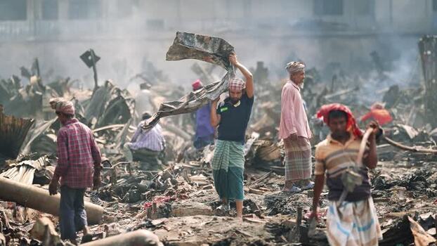 View of men walking through fire debris in Dhaka Bangladesh. View of men walking through fire debris in Dhaka Bangladesh.