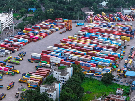 Aerial view of Chattogram Port featuring rows of colorful shipping containers stacked in the terminal with trucks and transport vehicles in Chittagong Chittagong Division Bangladesh.