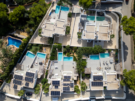 Aerial view of modern residential villas with private swimming pools and solar panels on rooftops Moraira Valencian Community Spain.