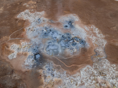 Aerial view of bubbling geothermal mud pots at the Hverir geothermal area with colorful mineral deposits and steaming vents in Reykjahlid Thingeyjarsveit Iceland. Aerial view of bubbling geothermal mud pots at the Hverir geothermal area with colorful mineral deposits and steaming vents in Reykjahlid Thingeyjarsveit Iceland.