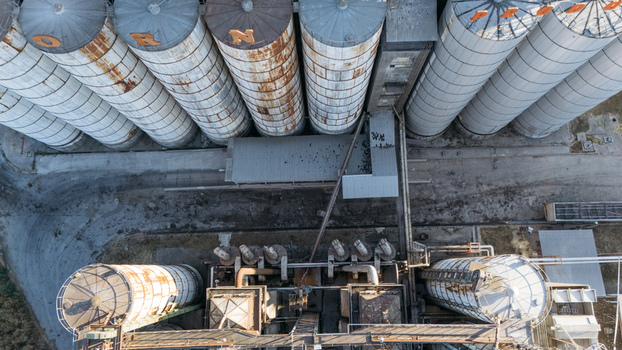 Aerial view of industrial grain silos with weathered metal surfaces and connecting pipes in Sremska Mitrovica Vojvodina Serbia. Aerial view of industrial grain silos with weathered metal surfaces and connecting pipes in Sremska Mitrovica Vojvodina Serbia.