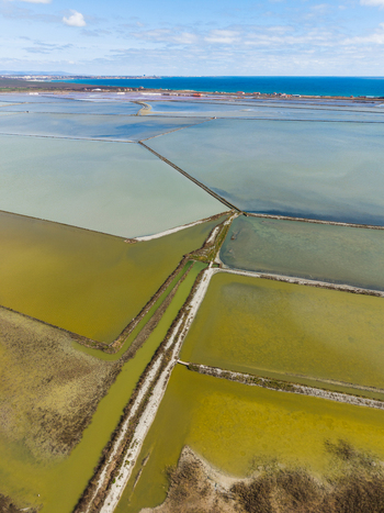 Aerial view of Lake Atanasovsko salt pans with multicolored evaporation ponds and narrow dams under a blue sky Burgas Burgas Bulgaria. Aerial view of Lake Atanasovsko salt pans with multicolored evaporation ponds and narrow dams under a blue sky Burgas Burgas Bulgaria.