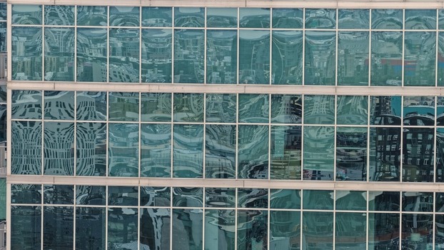 Aerial view of the modern glass facade of a building reflecting the surrounding urban landscape with geometric patterns and steel frames in Denver Colorado United States. Aerial view of the modern glass facade of a building reflecting the surrounding urban landscape with geometric patterns and steel frames in Denver Colorado United States.