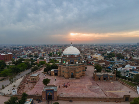 Aerial view of the historic Tomb of Shah Rukn e Alam with its iconic dome and intricate brickwork surrounded by the urban landscape of Multan at sunset Multan Punjab Pakistan.