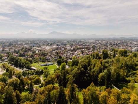 Aerial view of Tivoli Park surrounded by lush green trees and walking paths with the city skyline of Ljubljana in the background Ljubljana Slovenia.