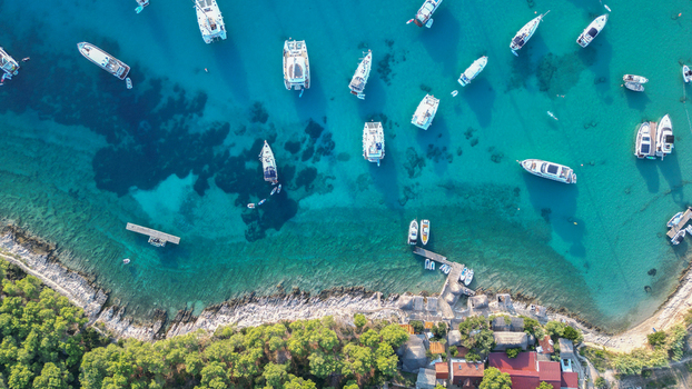Hvar Croatia 21 August 2023 Aerial view of Vinogradisce bay with numerous yachts anchored in turquoise waters along the rocky coastline and lush pine trees. Hvar Croatia 21 August 2023 Aerial view of Vinogradisce bay with numerous yachts anchored in turquoise waters along the rocky coastline and lush pine trees.