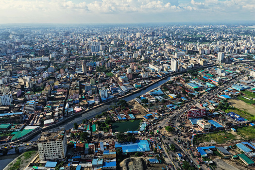 Aerial view of the Karnaphuli River winding through the dense urban landscape of Chattogram with high rise buildings and busy streets in Chattogram Chittagong Division Bangladesh.