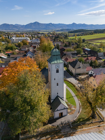 Aerial view of a white church autumn trees village homes and distant mountains Klastor pod Znievom Zilina Region Slovakia. Aerial view of a white church autumn trees village homes and distant mountains Klastor pod Znievom Zilina Region Slovakia.