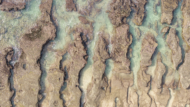 Aerial view of the rugged rock formations and clear turquoise tide pools at Hartenbos in Mossel Bay Western Cape South Africa. Aerial view of the rugged rock formations and clear turquoise tide pools at Hartenbos in Mossel Bay Western Cape South Africa.